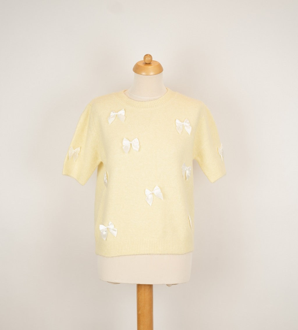 Zachtgeel truitje met witte strikken